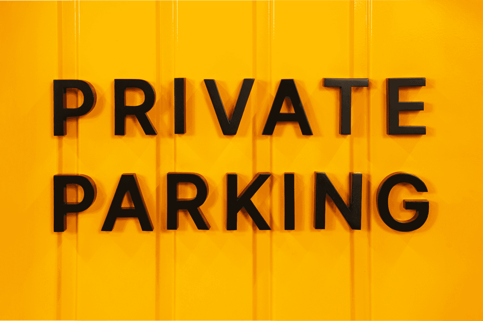 Żółty metalowy znak parking prywatny