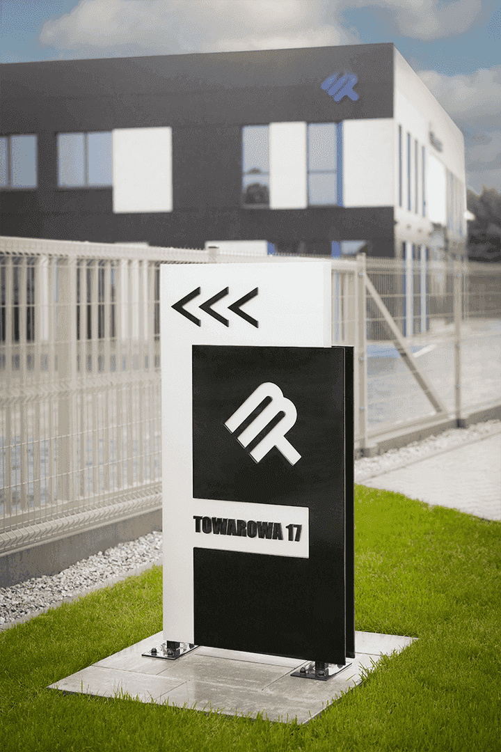 Pilón publicitario con logotipo sobre fondo de edificio de empresa