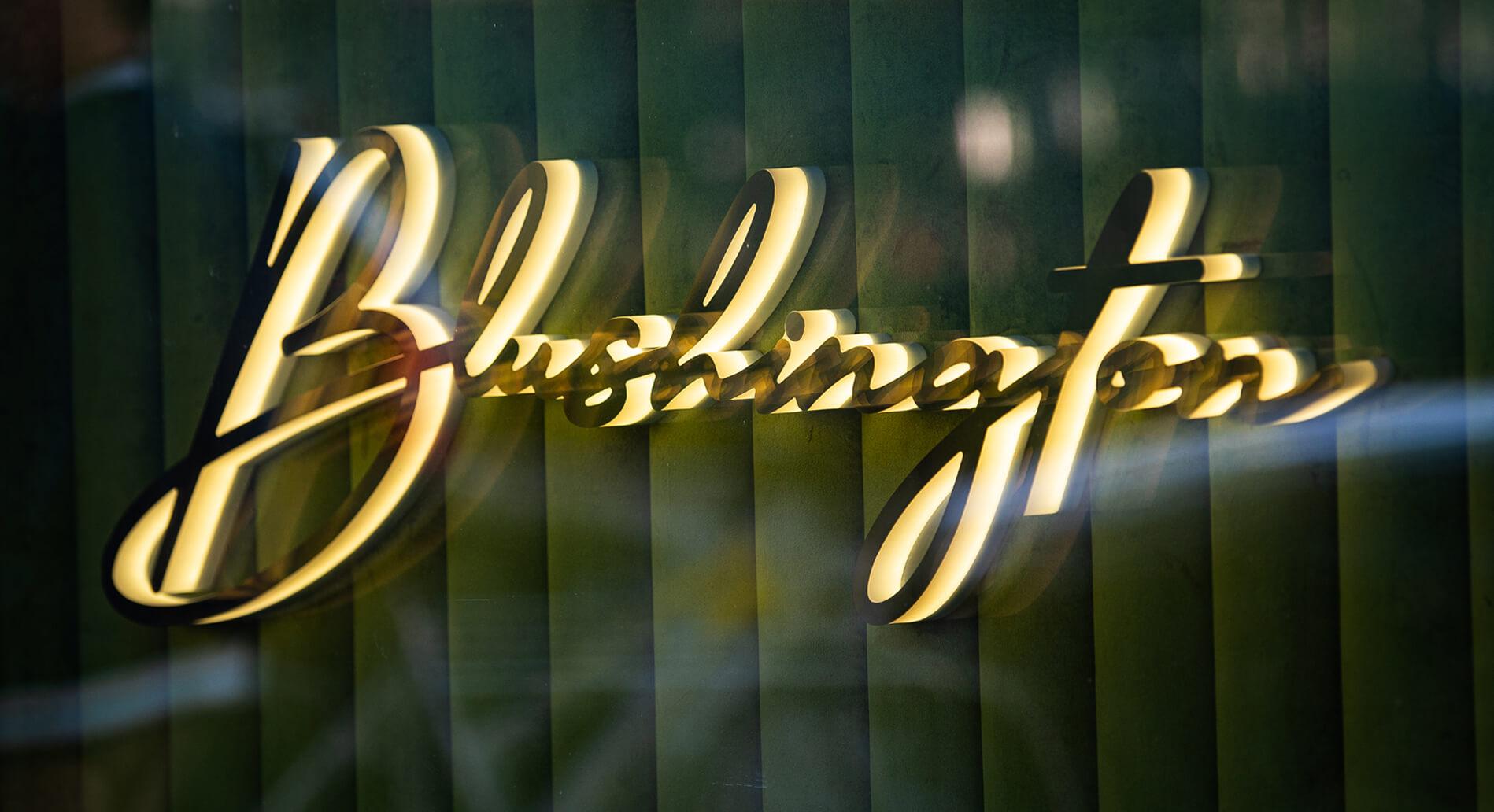 Blushington letters glowing LED side, in gold color.