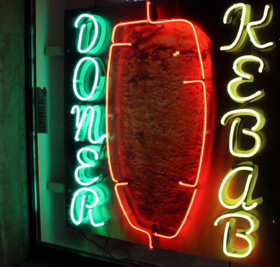 Doner Kebab - enseigne publicitaire en néon coloré, placée derrière la vitrine du magasin