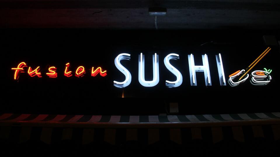 Fusion Sushi - enseigne publicitaire au néon, située au-dessus de l'entrée du bâtiment