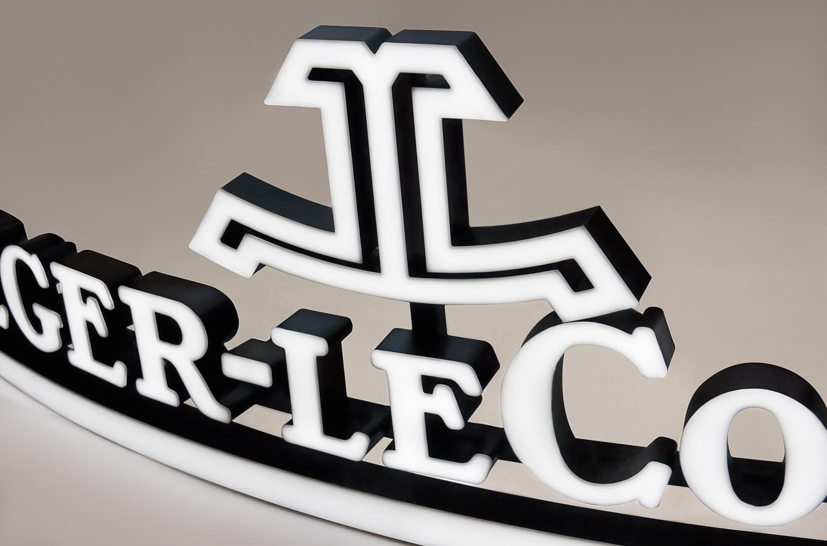 Jaeger-LeCoultre - logo z bliska świecące przodem w białym kolorze