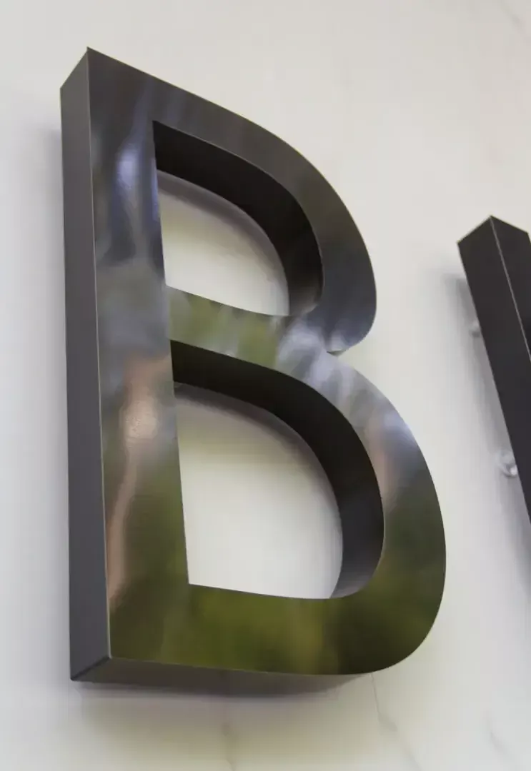 Letter B in brushed stainless steel - Letter B in brushed stainless steel with black polished titanium color.