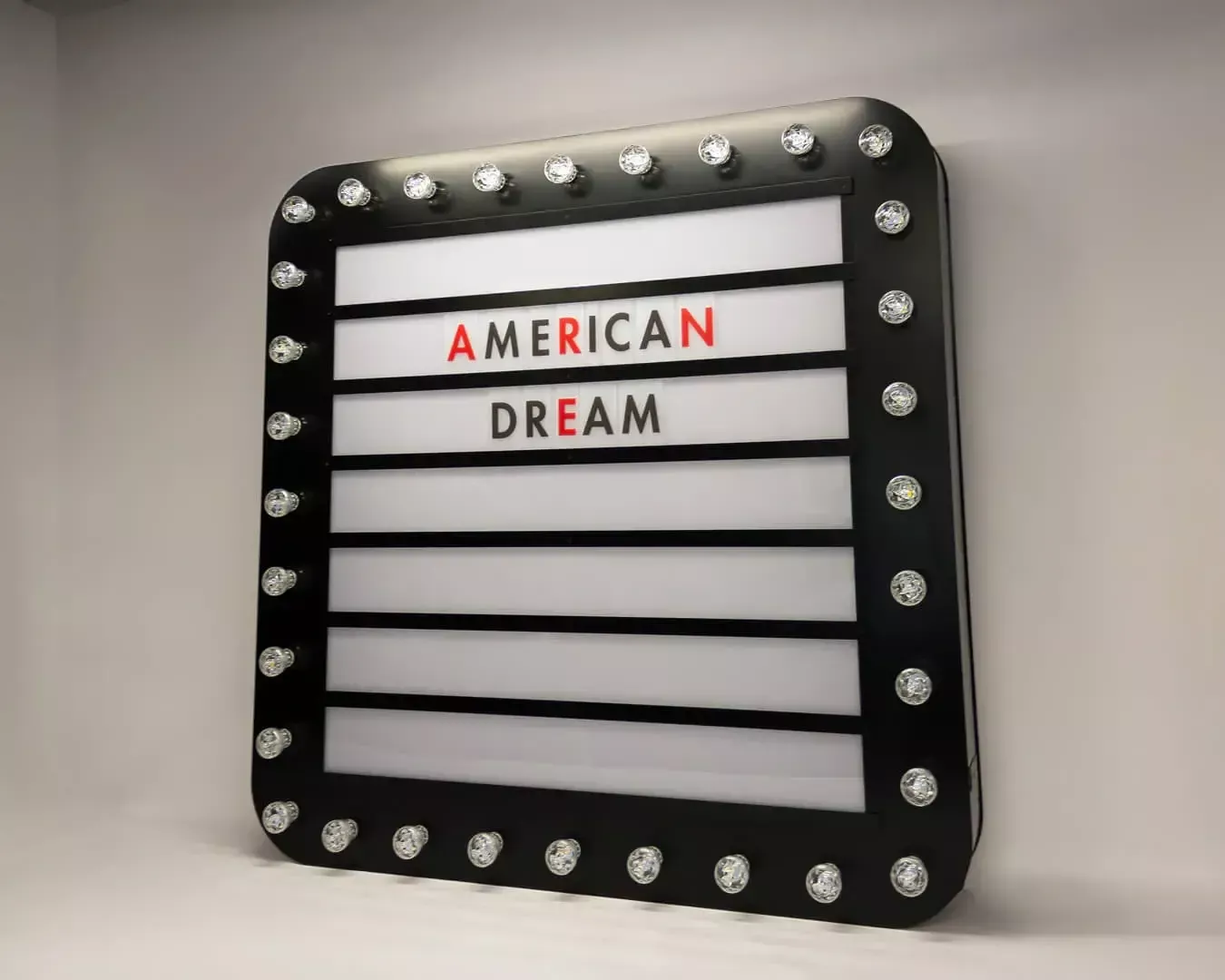 Il sogno americano - Una lavagna a forma di lampadina, con lettere intercambiabili, in stile retrò.