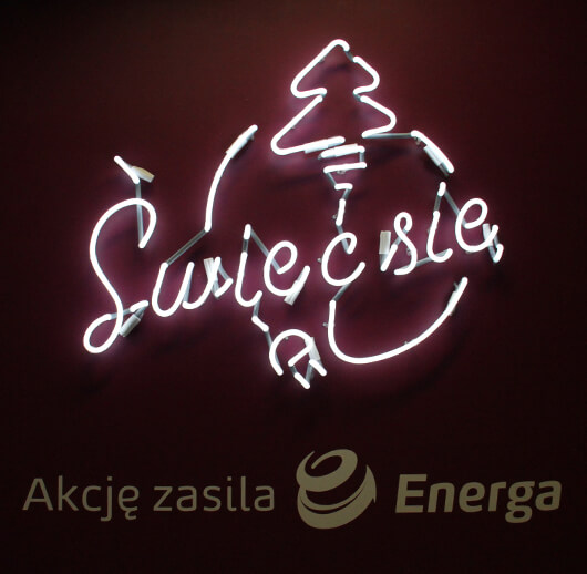 Shine up - Energa - white neon advertising sign with symbols placed on the wall