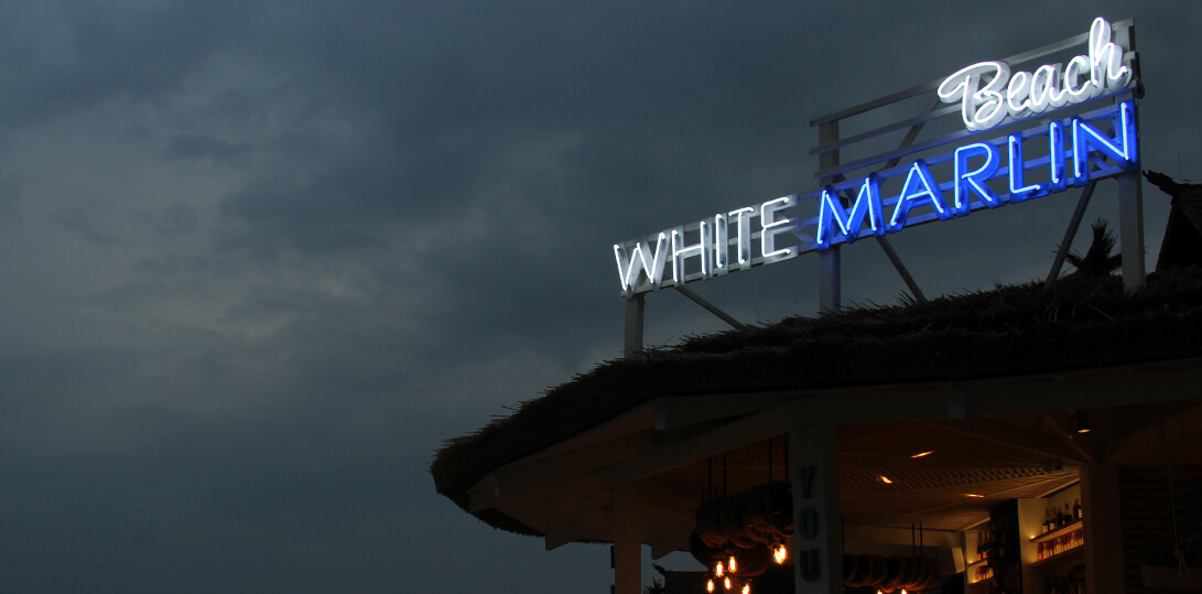 White Marlin - advertising neon sign placed on a frame, on the roof of the building