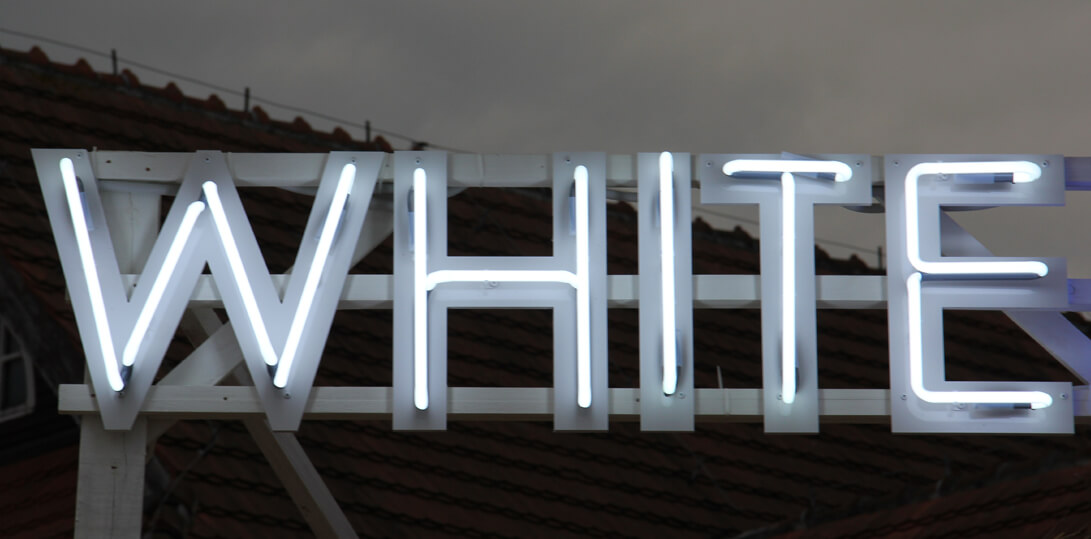 White Marlin - advertising neon sign placed on a frame, on the roof of the building