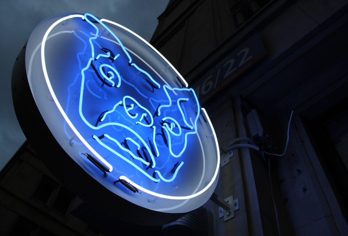 Bulldog - neon sign with company logo placed on advertising semaphore