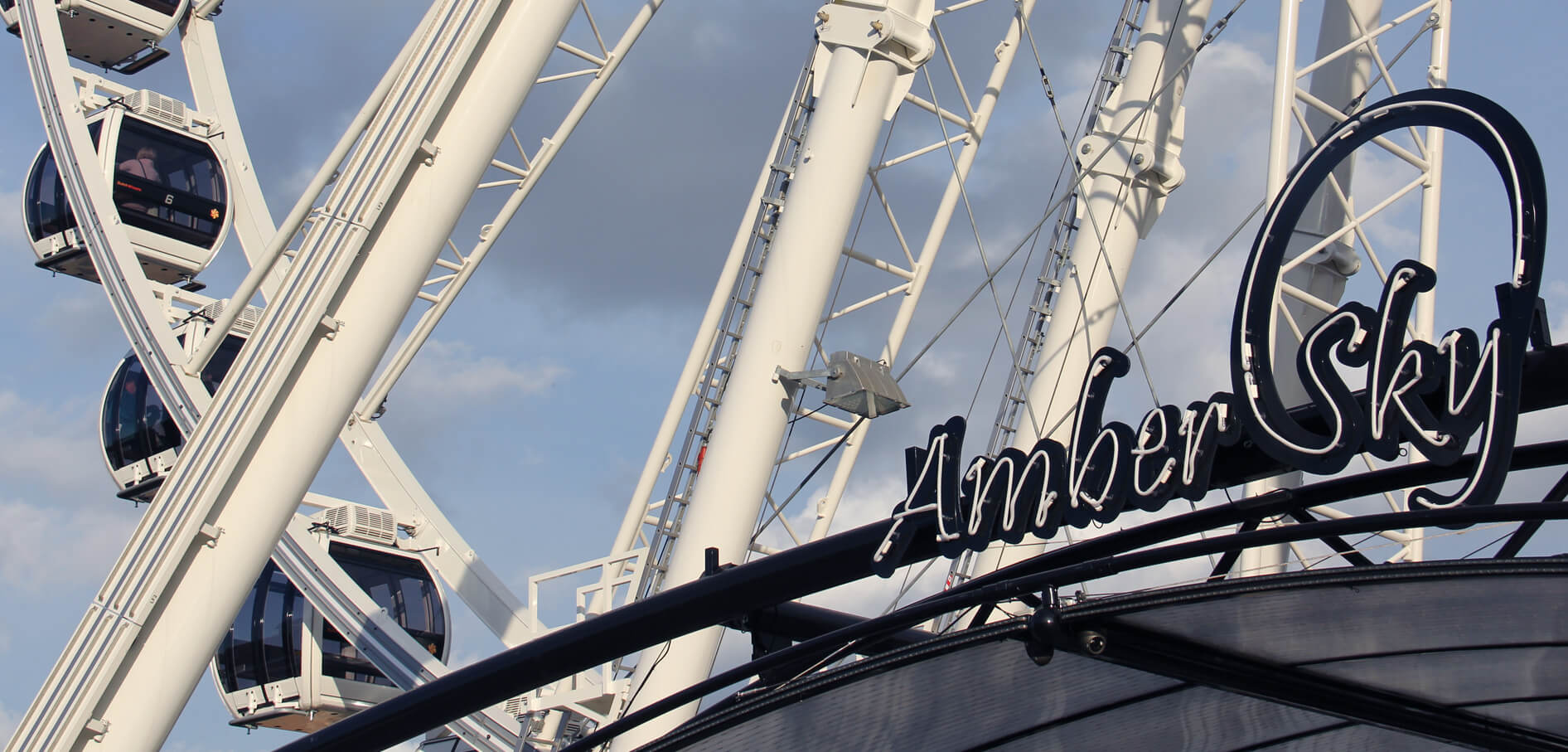 Amber Sky - letrero de neón blanco con el nombre de la empresa en el marco