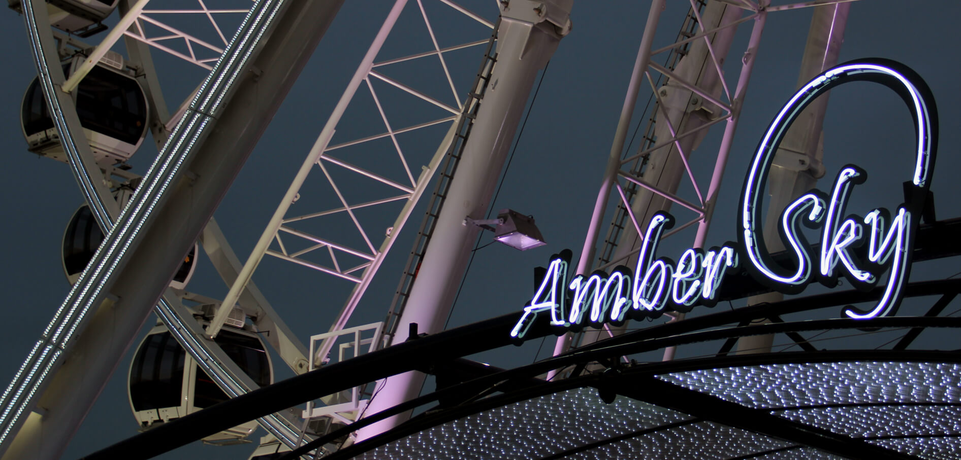 Amber Sky - letrero de neón blanco con el nombre de la empresa en el marco