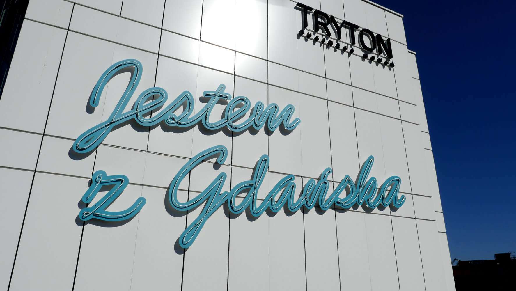 Triton - Aufschrift "I am from Gdansk" aus Neonschildern, die an der Fassade angebracht sind