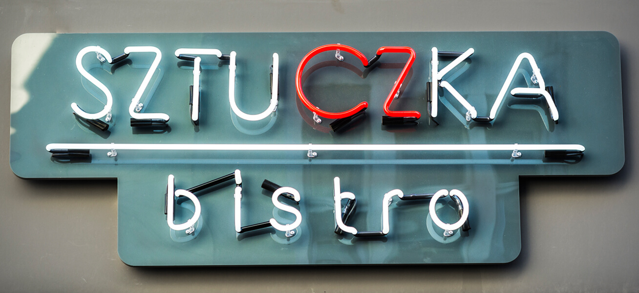 Trick Bistro - advertising neon sign, mounted on a plexiglass panel, placed above the entrance