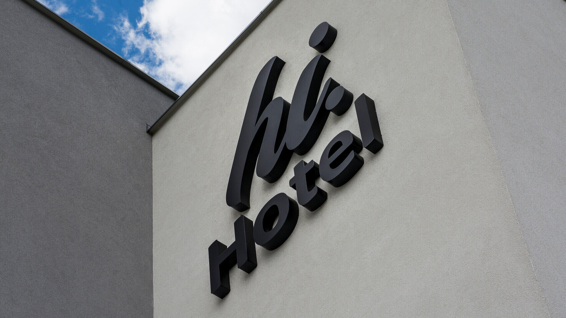 hi-hotel-neon-sul-muro-neon-dietro-il-pannello-neon-sottoilluminato-neon-all'ingresso-neon-sull'altezza-neon-linee-neon-bianco-logo-azienda-neon-sul-calcestruzzo-gdansk-lotnisko (4)