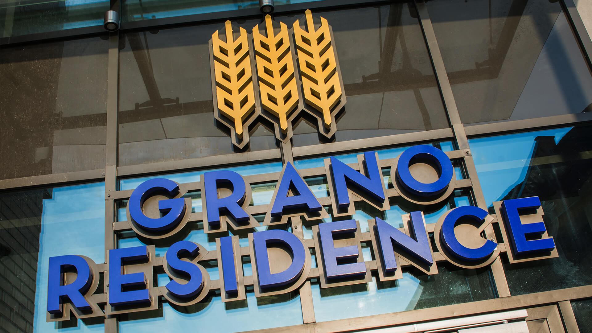 grano-residence-literature-space-lit-back-lit-blue-literature-above-entry-to-hotel-literature-mounted-on-capital-literature-on-stack-logo-firm-3d-gdansk