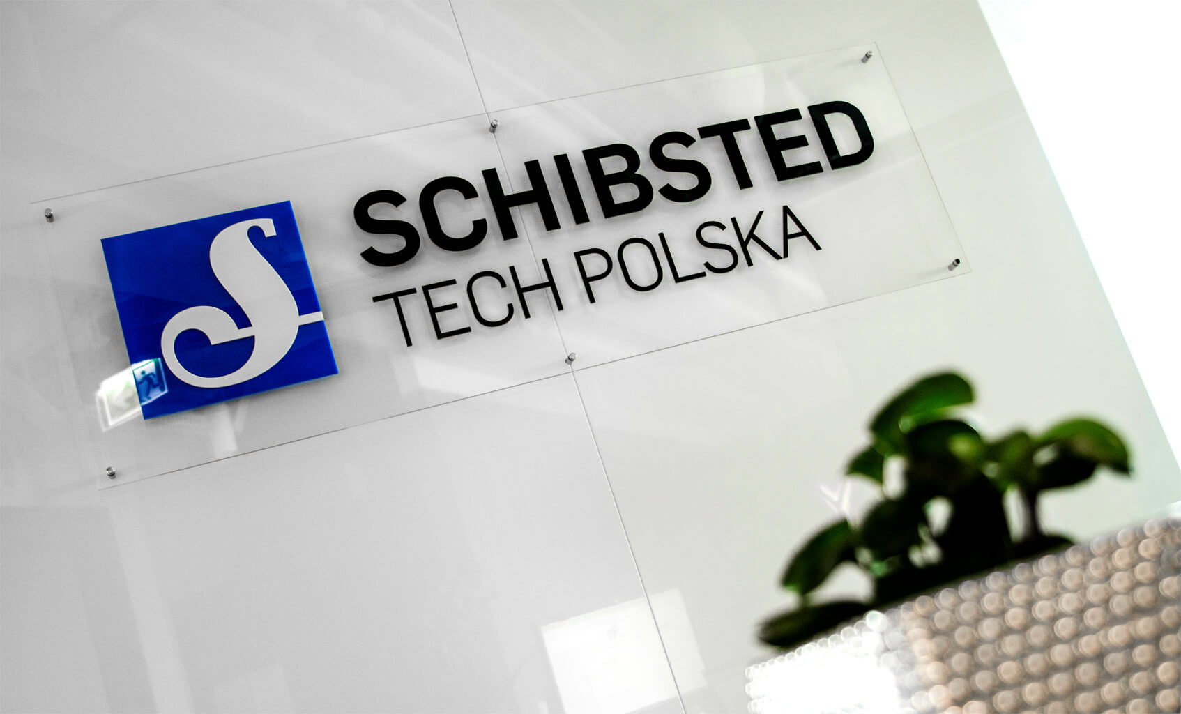 Schibsted Tech Polska - 3D-Logo und räumliche Buchstaben auf Plexiglassockel im Empfangsbereich