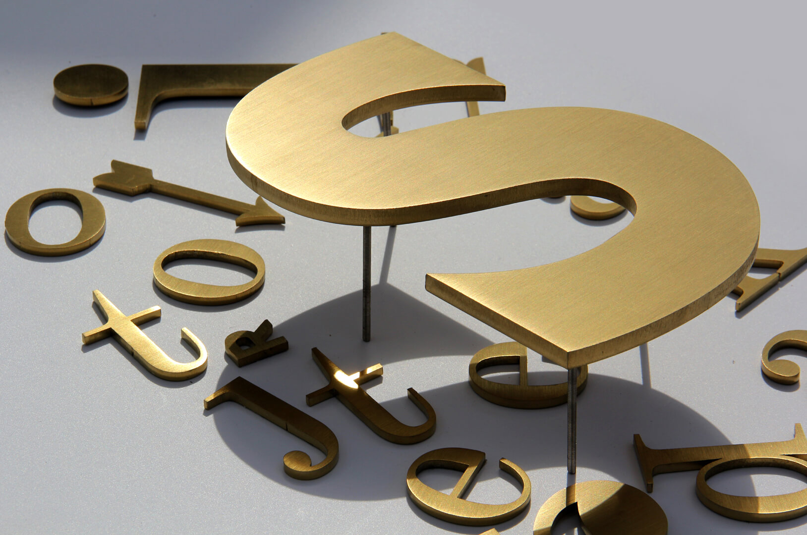 Metal letters in gold color, industrial style.