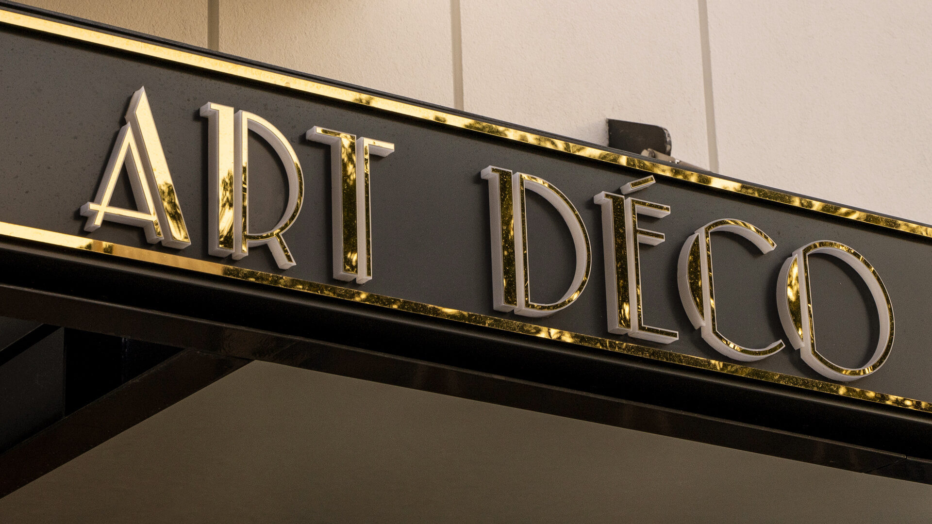 Gold colored dibond coffer over Art Deco Mokotow entrance.