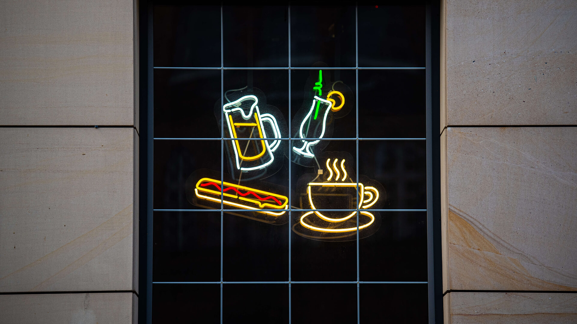 Green neon Pub Cafe sign with directions to the entrance.