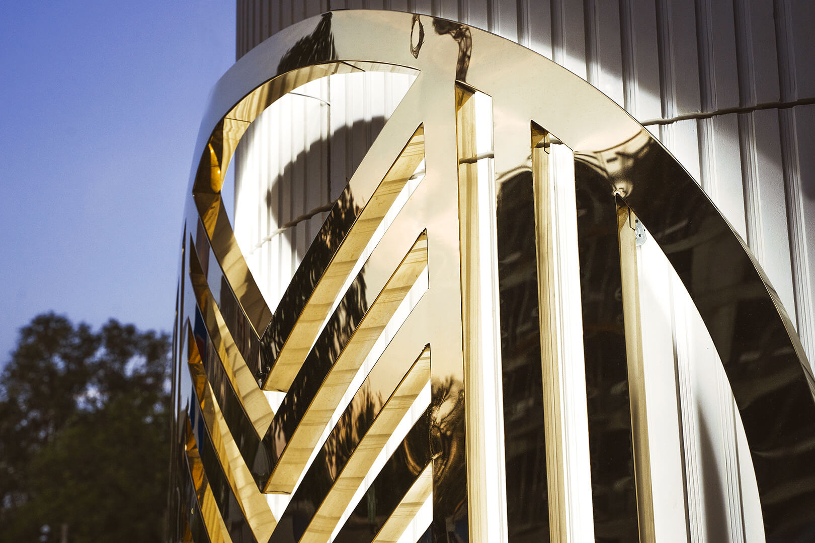 Back-lit logo on the wall, rounded in an arc, made of stainless steel.