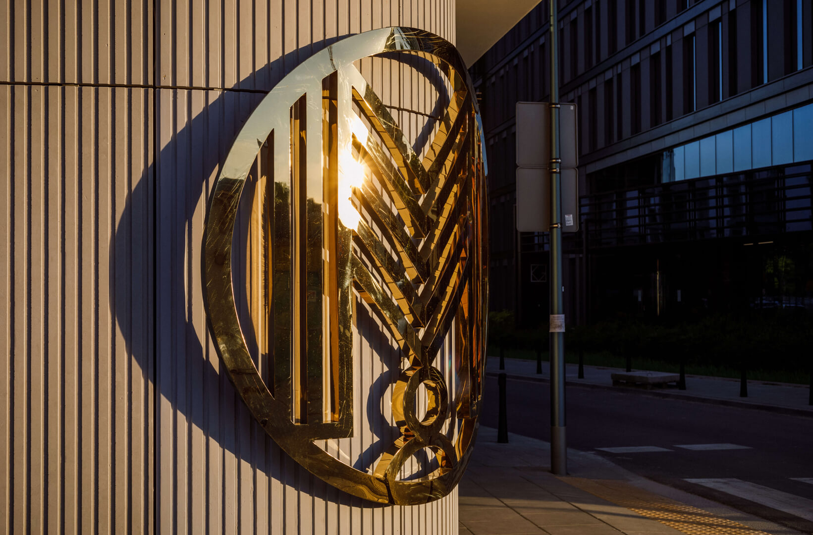 Rounded stainless steel logo in gold.