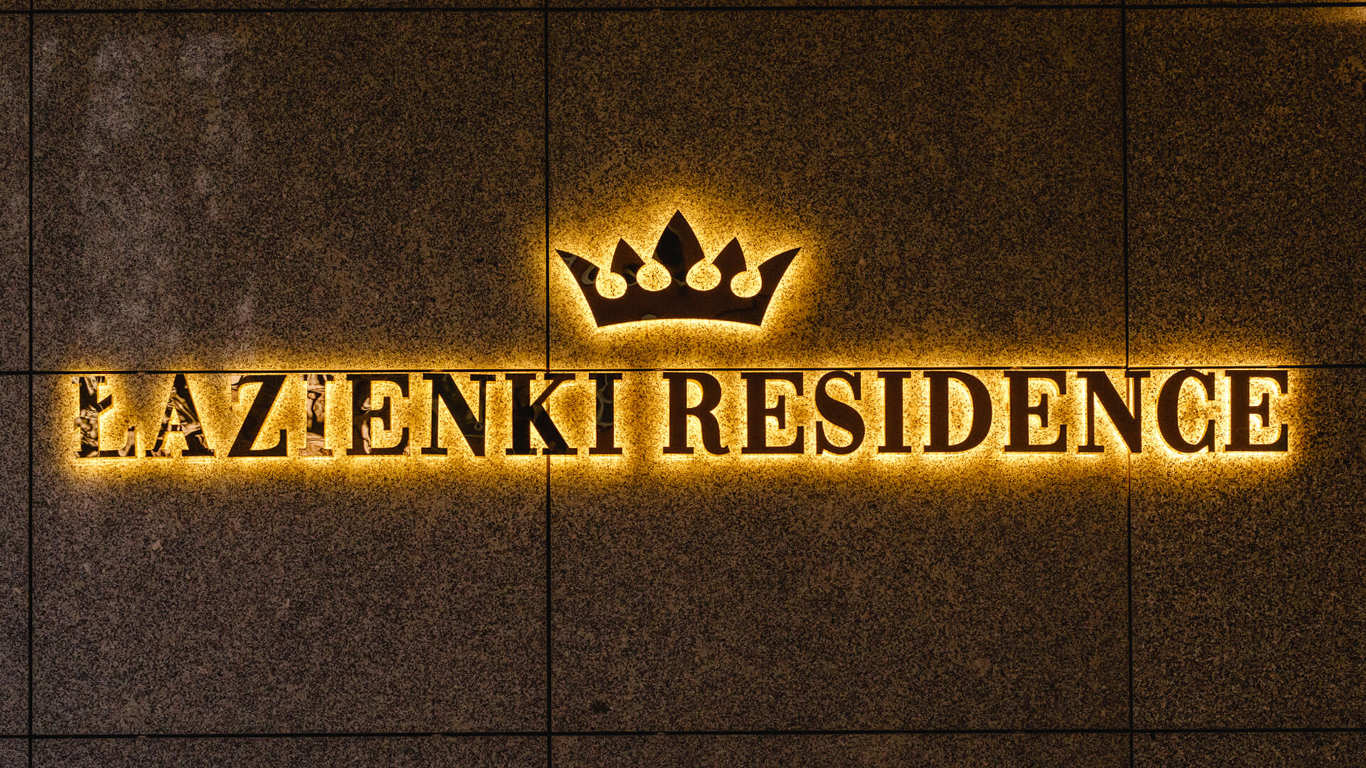 Bathroom Residence lettering made of stainless steel in gold, back-lit LED on the wall, with a crown in the logo.