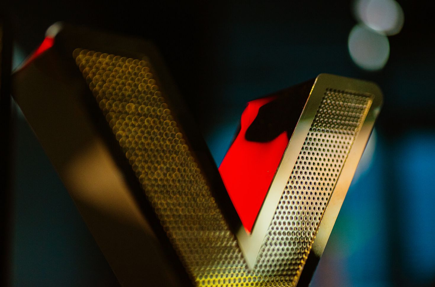 Letter made of gold perforated sheet metal, illuminated by LED.