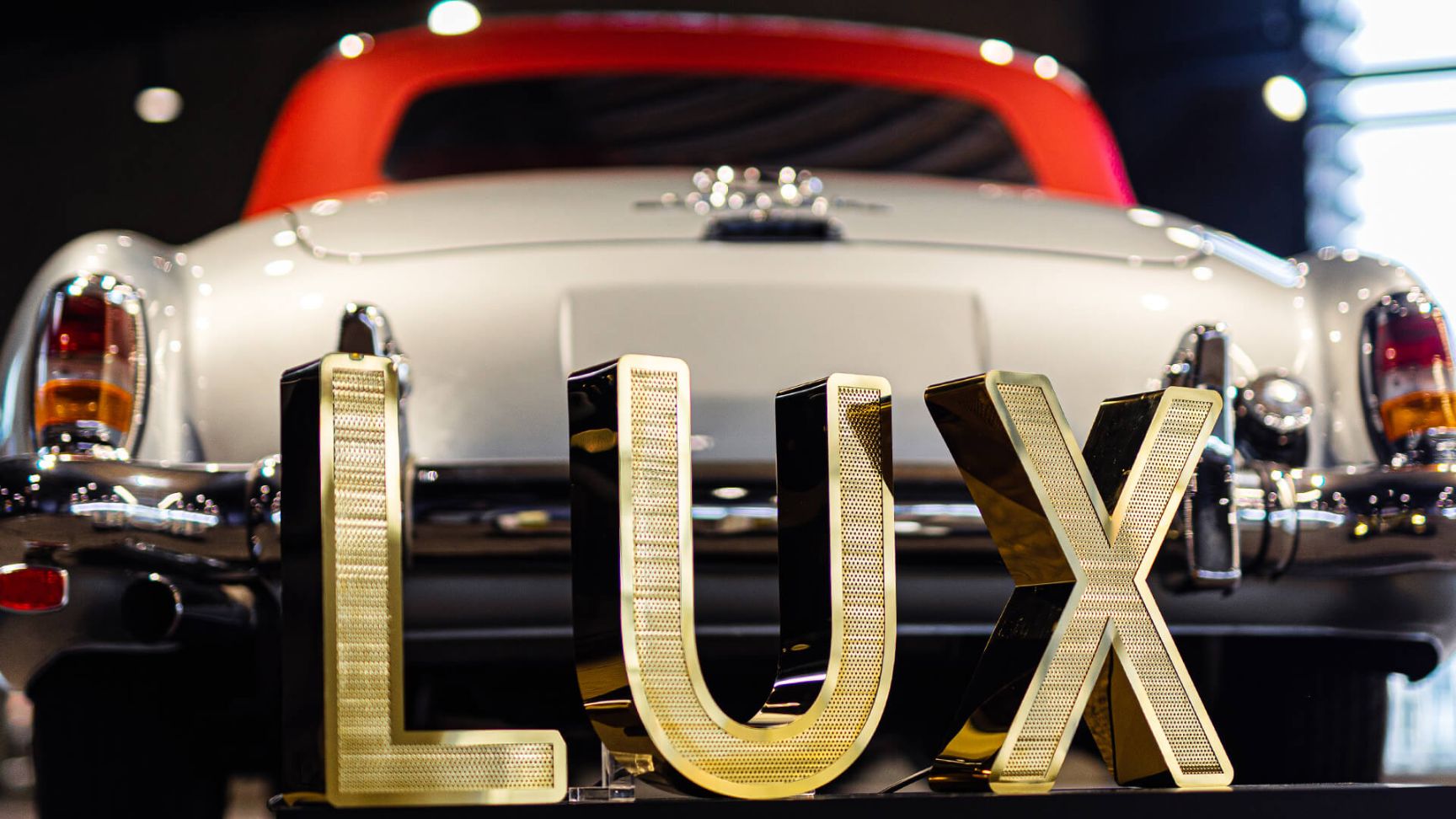 LUX inscription made of perforated stainless steel sheet, illuminated with LED, on the background of Mercedes