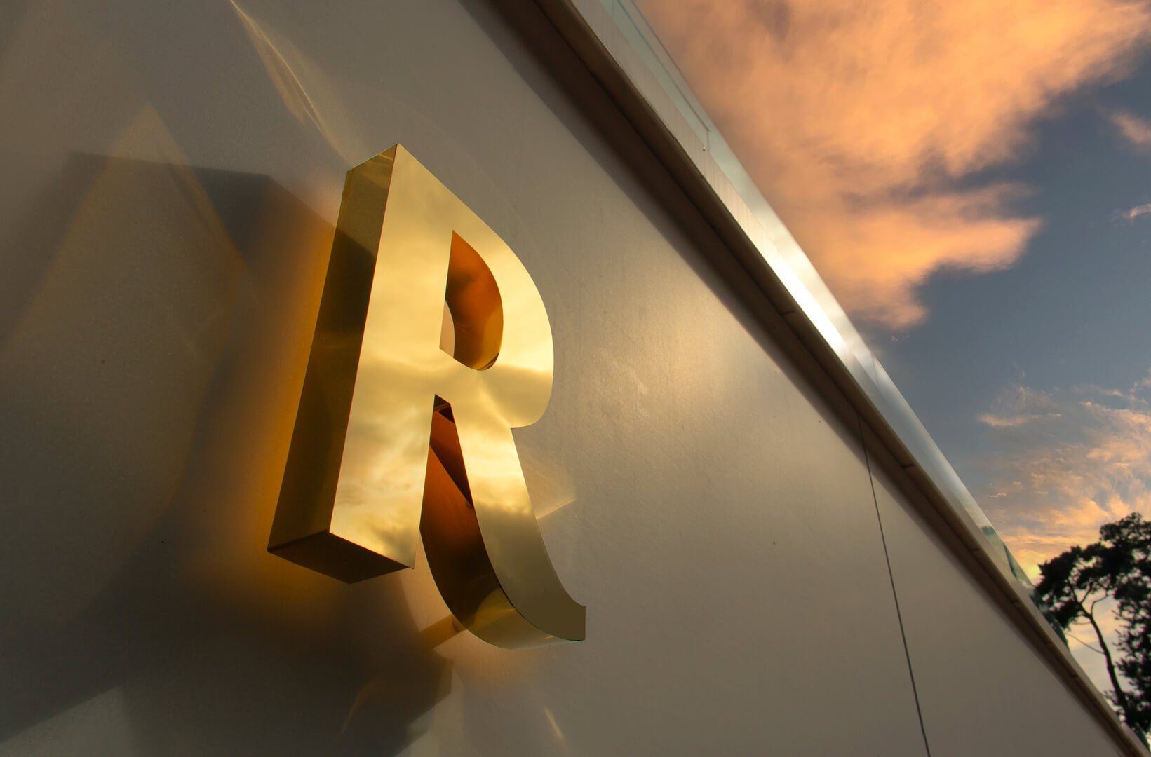letters made of gold polished stainless steel, back-lit on the wall