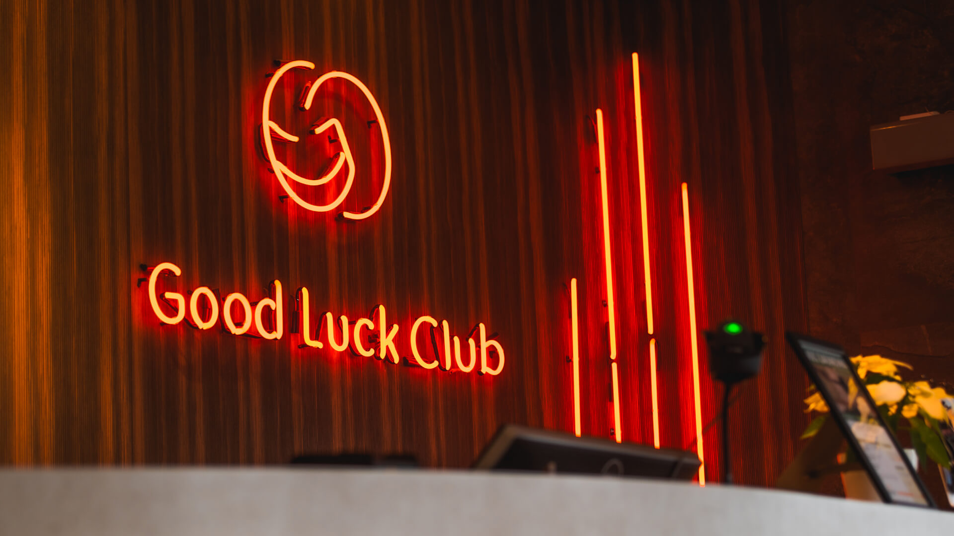 A red neon sign in the reception area along with the company logo.