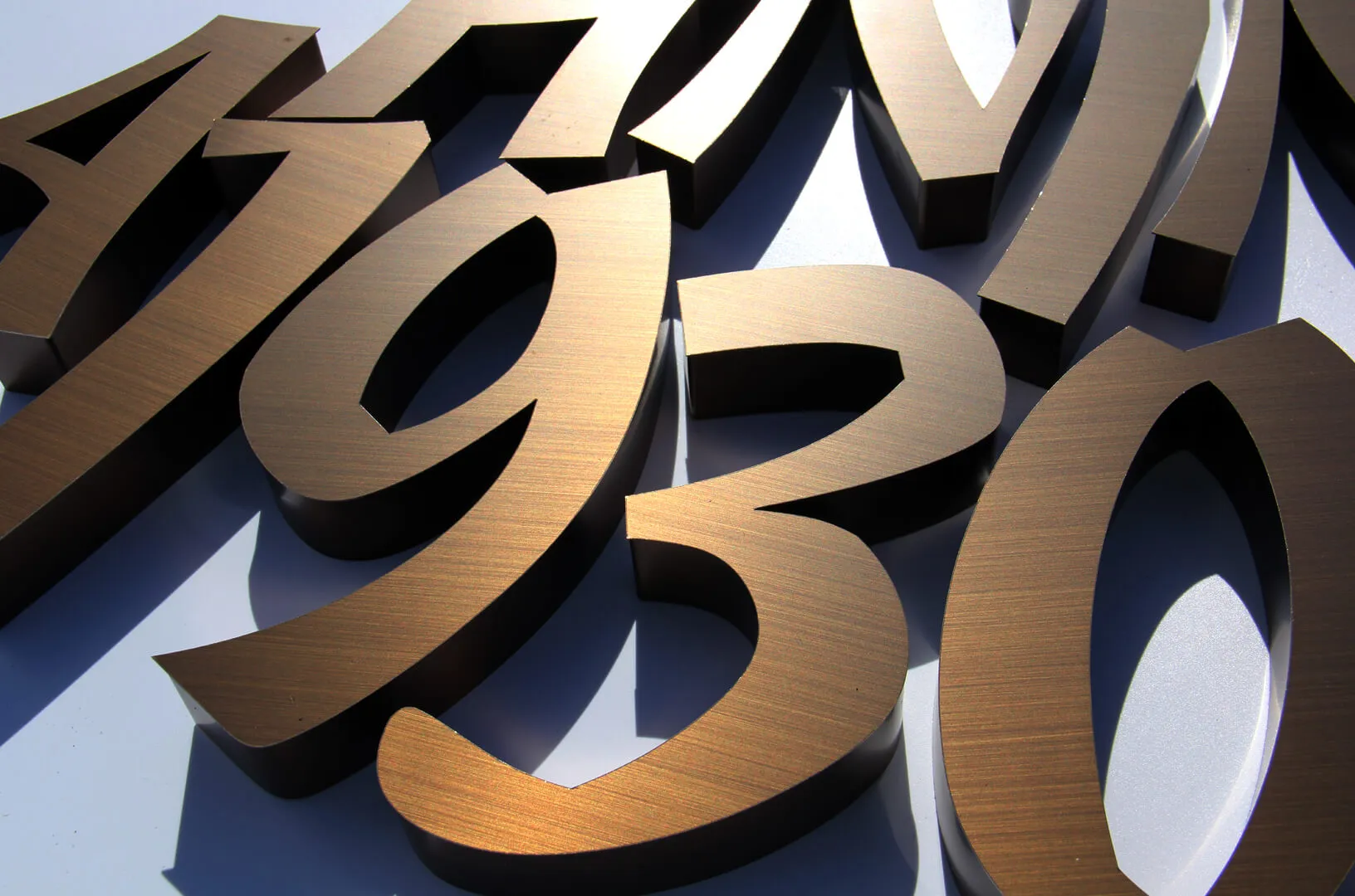 Numbers made of stainless steel in brushed bronze color.