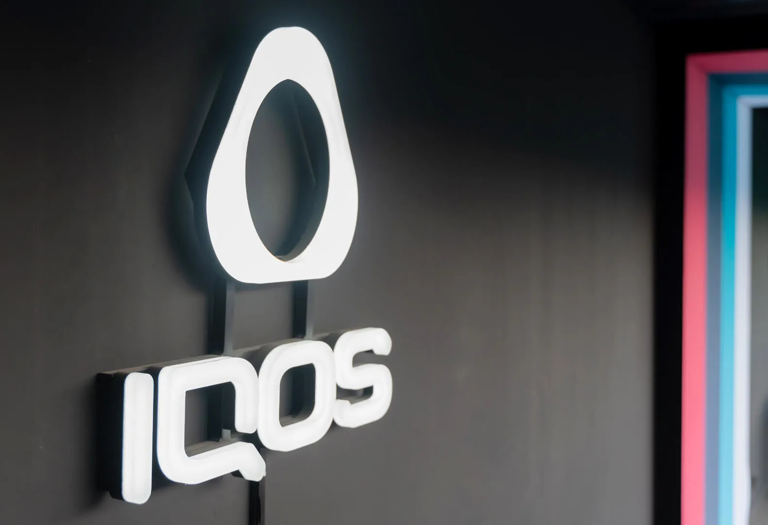 IQOS logo and lettering made of plexiglass, backlit in white