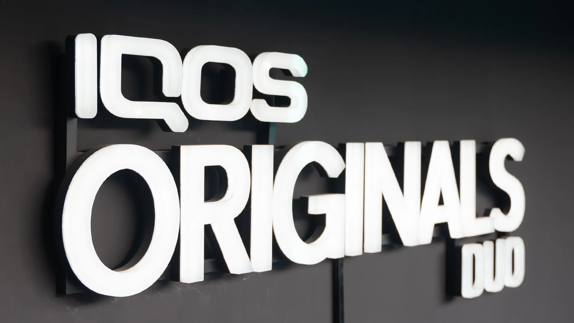 Logo and inscription IQOS ORIGINALS DUO made of plexiglass, backlit in white