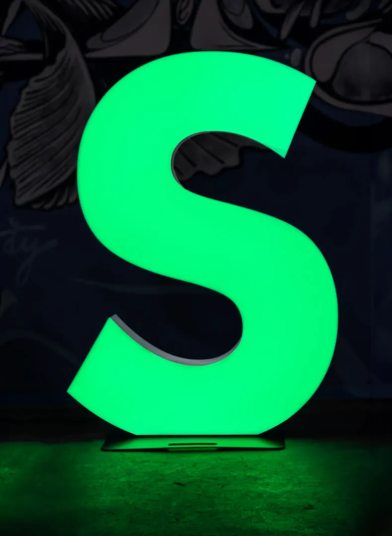 huge letter S illuminated in green color