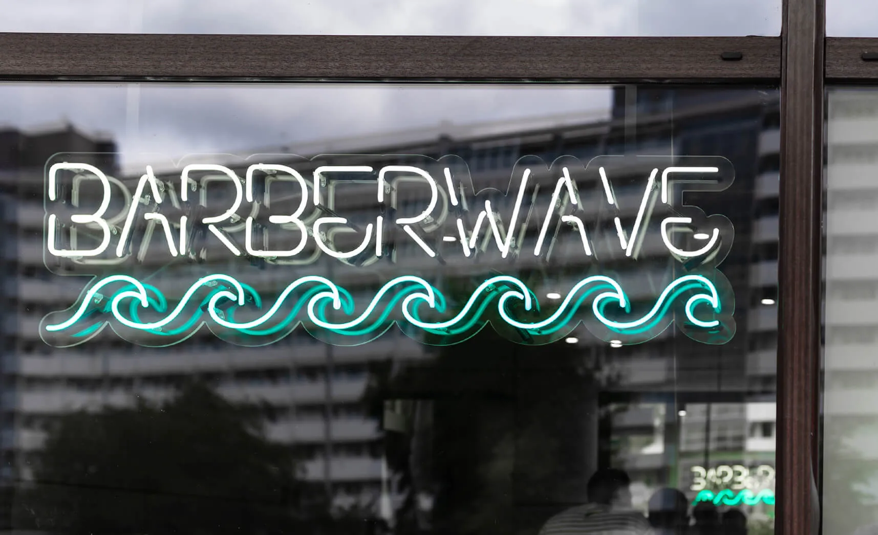 Neon sign on the window with the company name and wave in blue