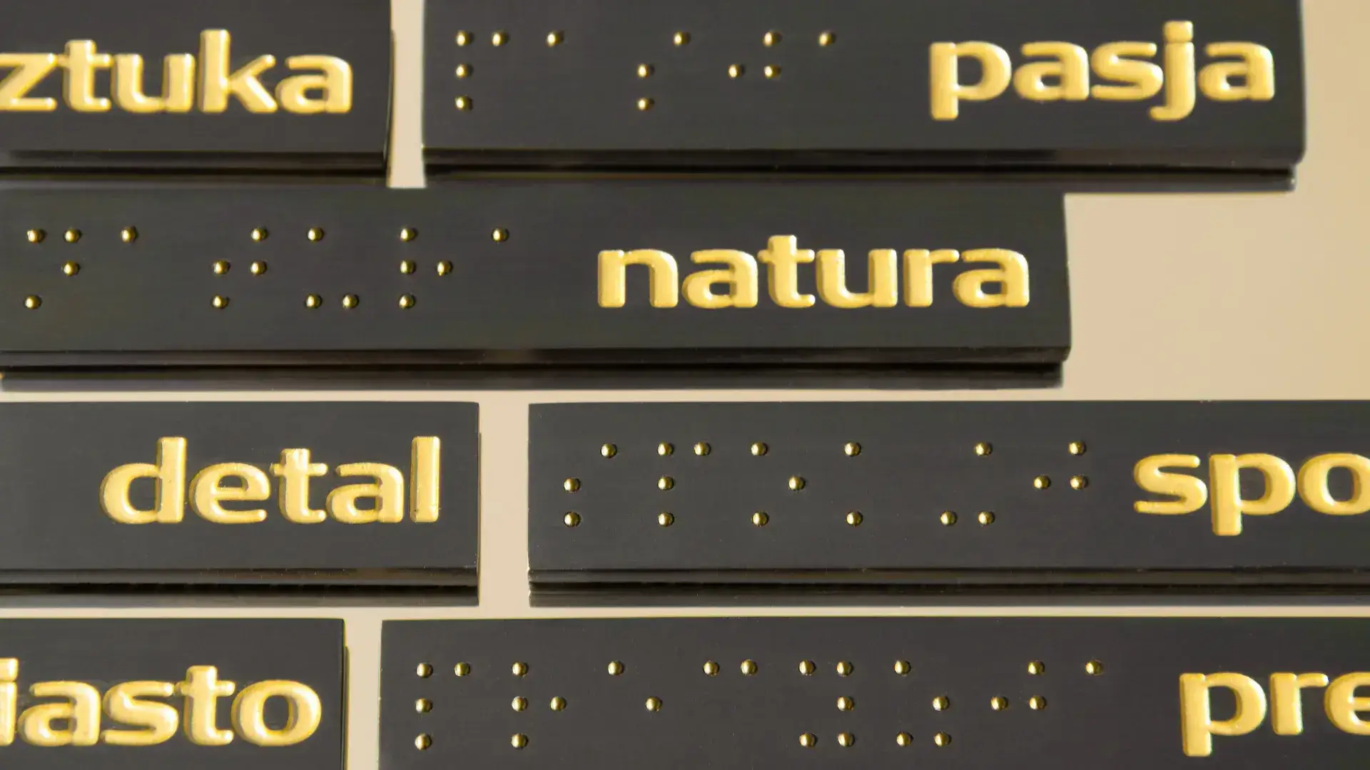 gold letters on black plate and Braille notation