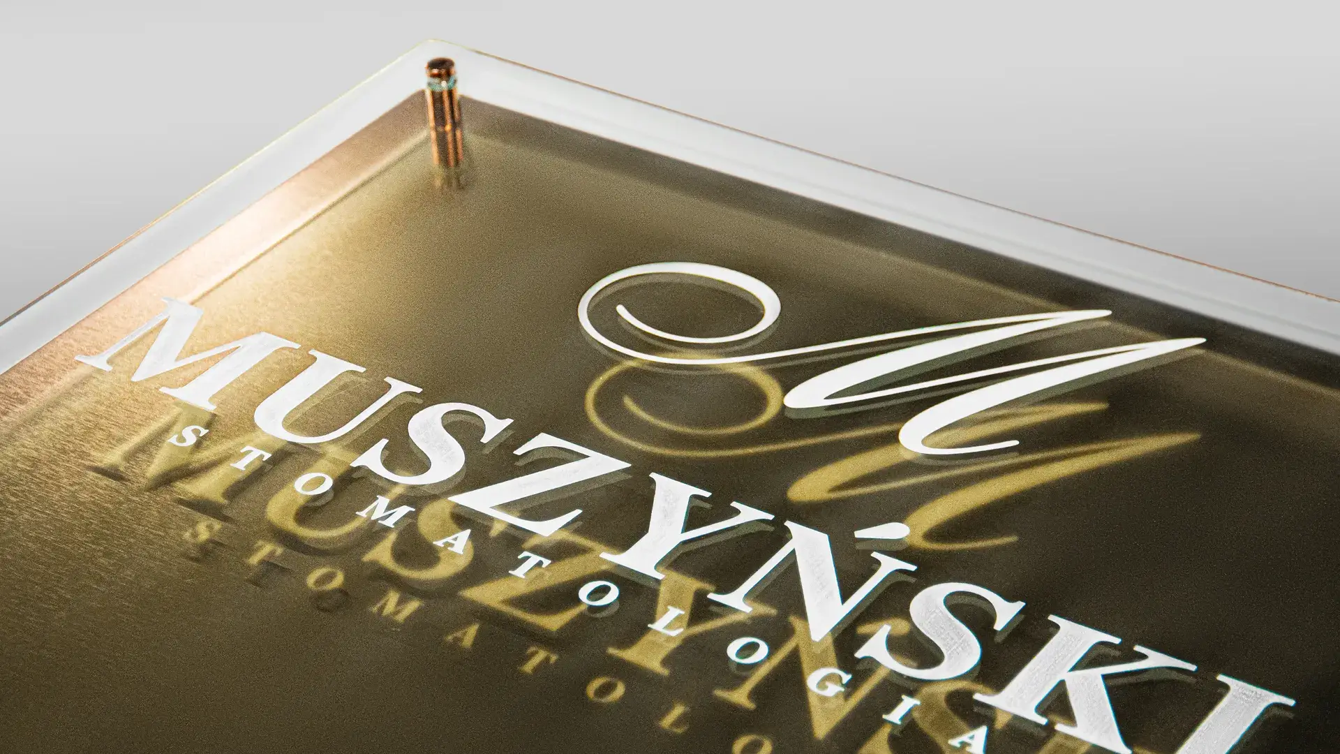 Złota tabliczka z logo 3D na czterech dystansach