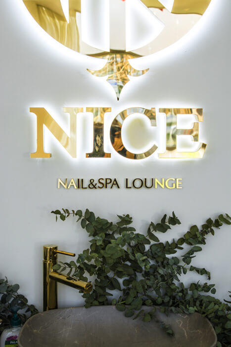 Nice - gold logo and led space letters in the reception area