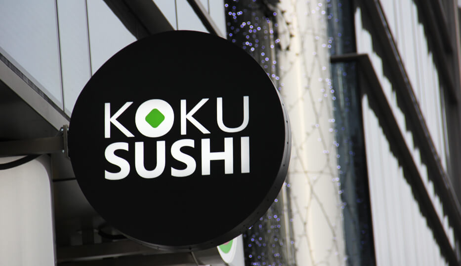 Koku Sushi - a circular light box advertising next to the entrance