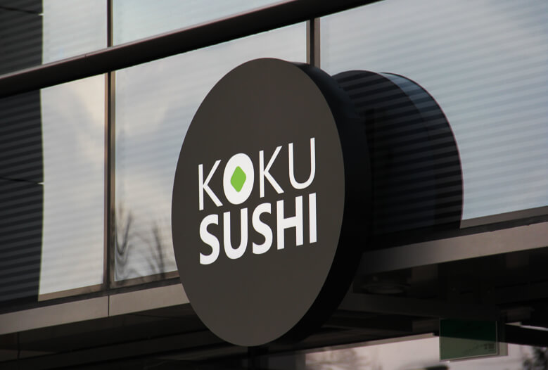 Koku Sushi - okrągły świetlny kaseton reklamowy obok wejścia