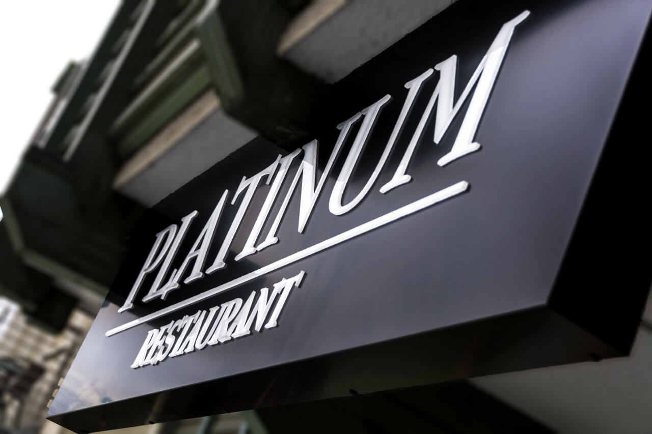 Platinum Restaurant - enseigne d'entreprise composée de lettres spatiales placées sur un caisson