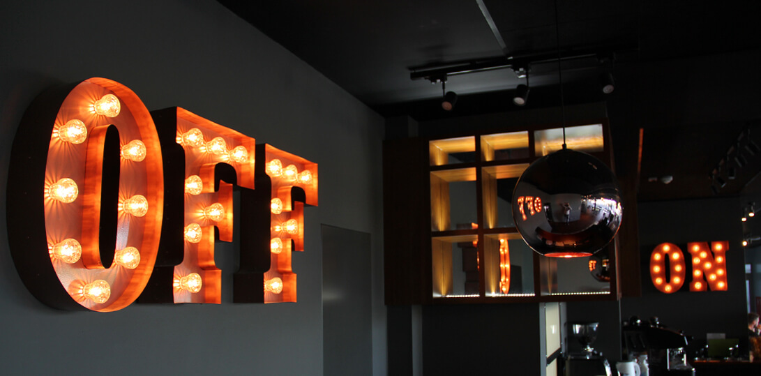 Letters filled with light bulbs on a wall inside a building