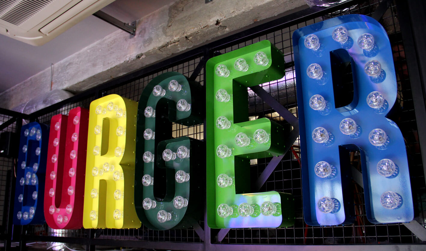 Burger - gekleurde letters met lampen boven de ingang