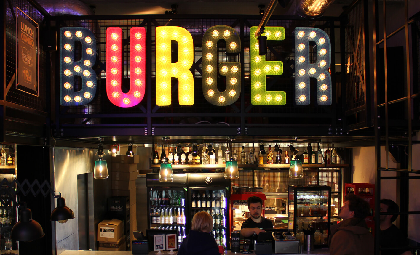 Burger - letras de colores con bombillas colocadas sobre la entrada