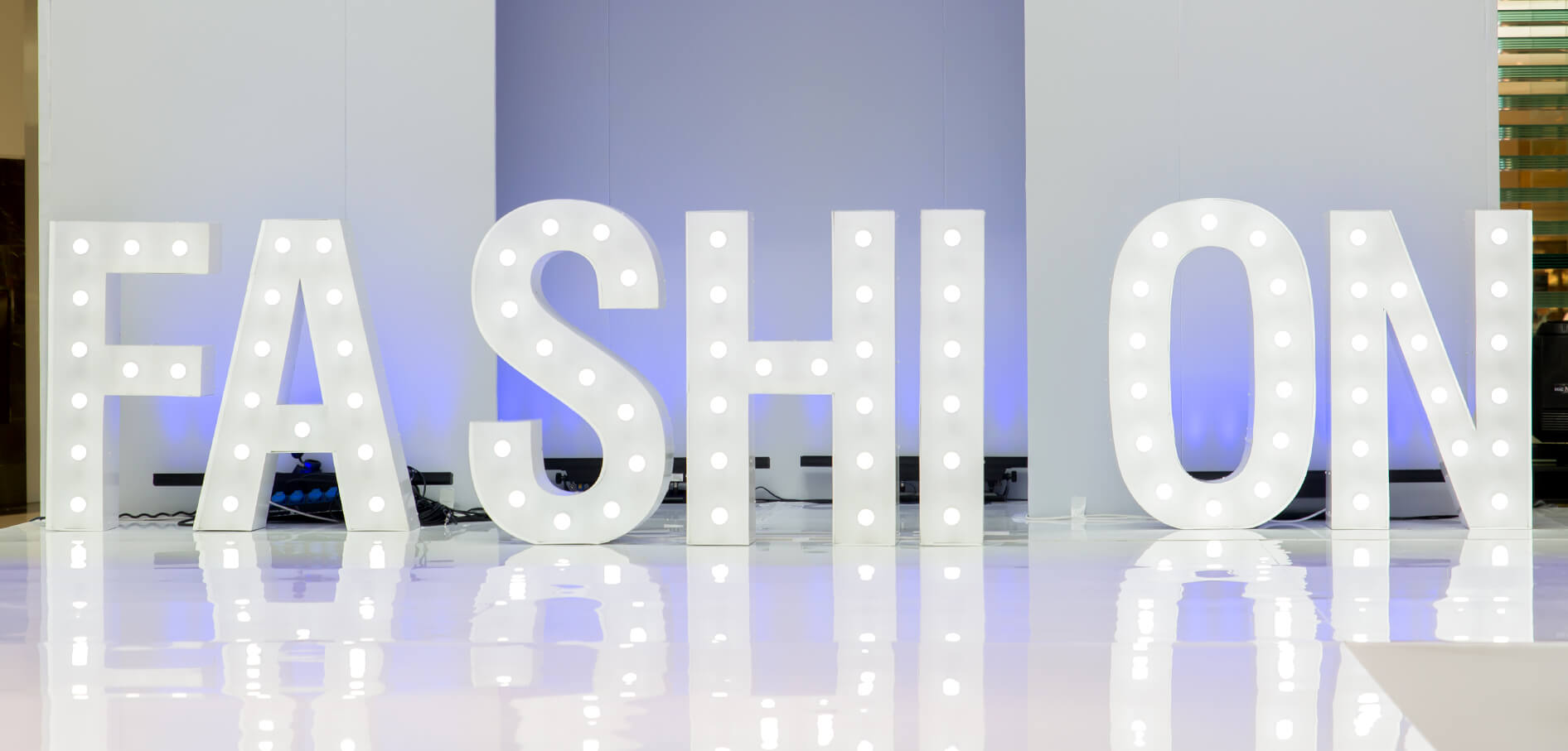 Fashion - letters with white bulbs on stage