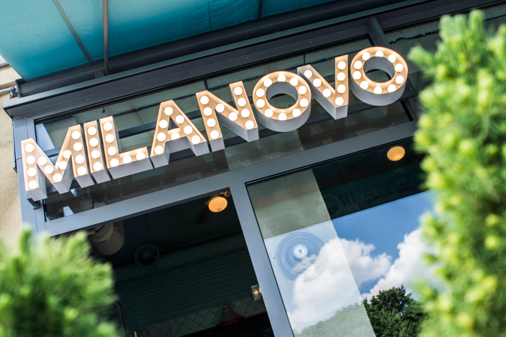 MILANOVO - Buchstaben mit Glühbirnen über dem Eingang des Restaurants