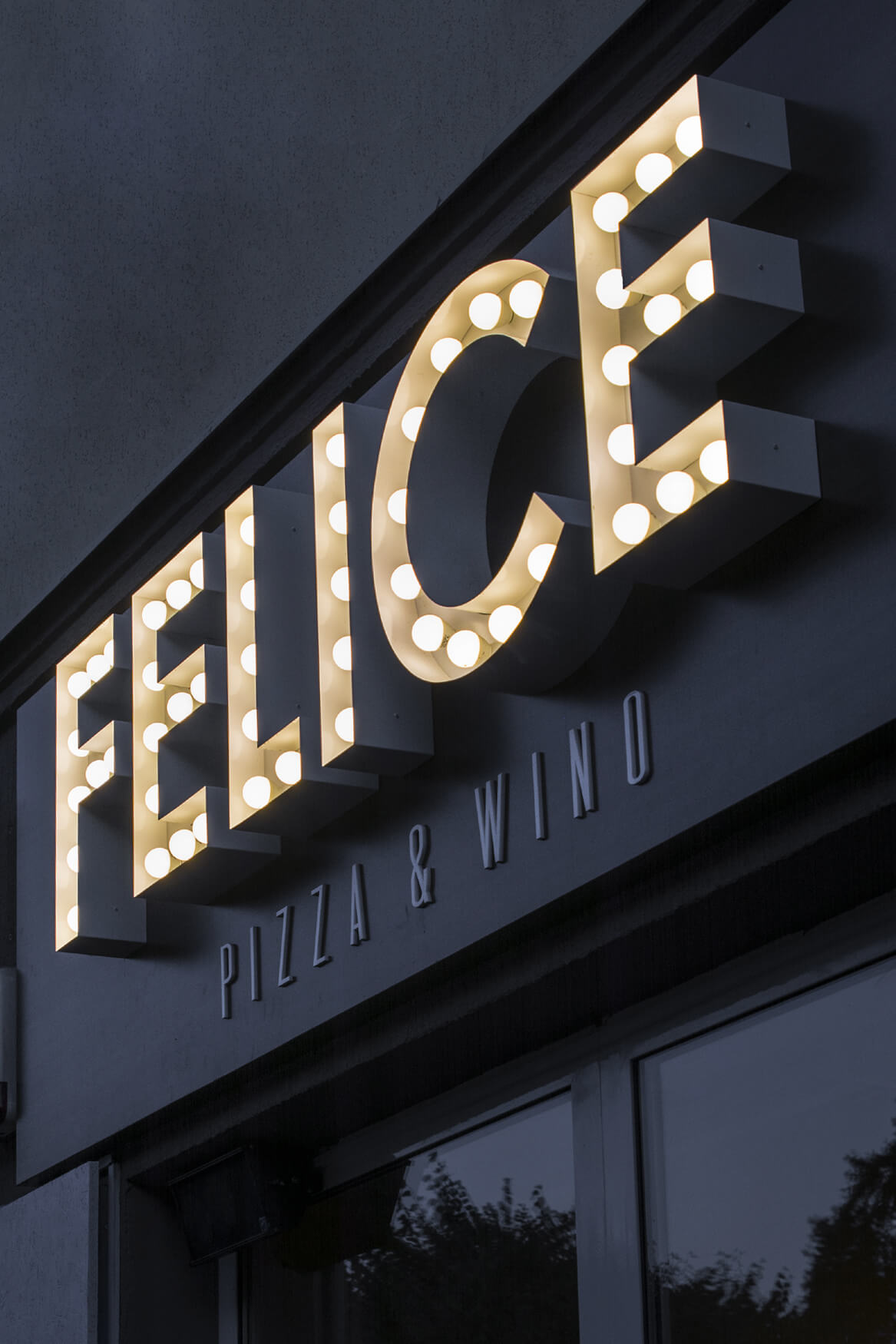 Felice - spatial letters with light bulbs above the entrance