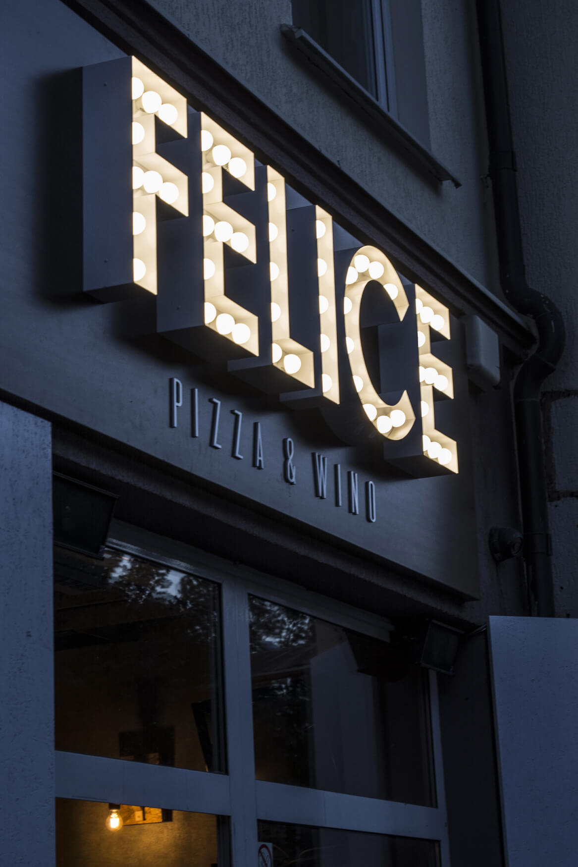 Felice - spatial letters with light bulbs above the entrance