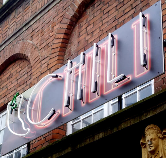 Chili - red advertising neon sign located above the entrance