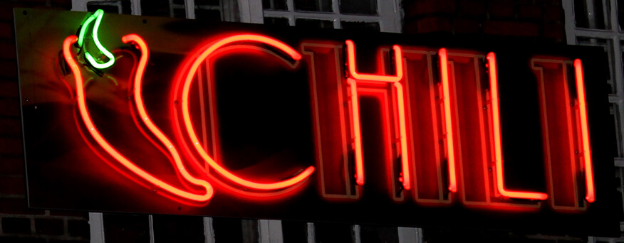 Chili - red advertising neon sign located above the entrance