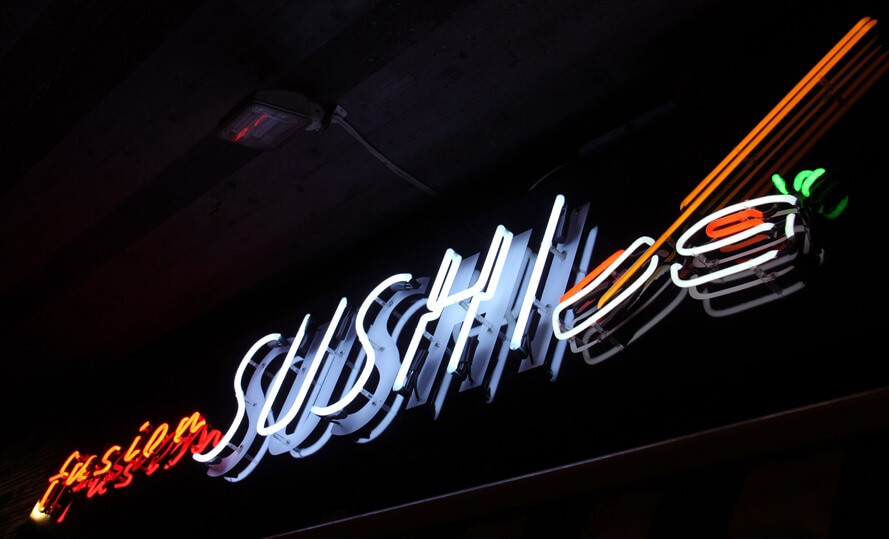 Fusion Sushi advertising neon sign, located above the entrance to the building